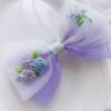 Handmade bow with detailed flower stitching.